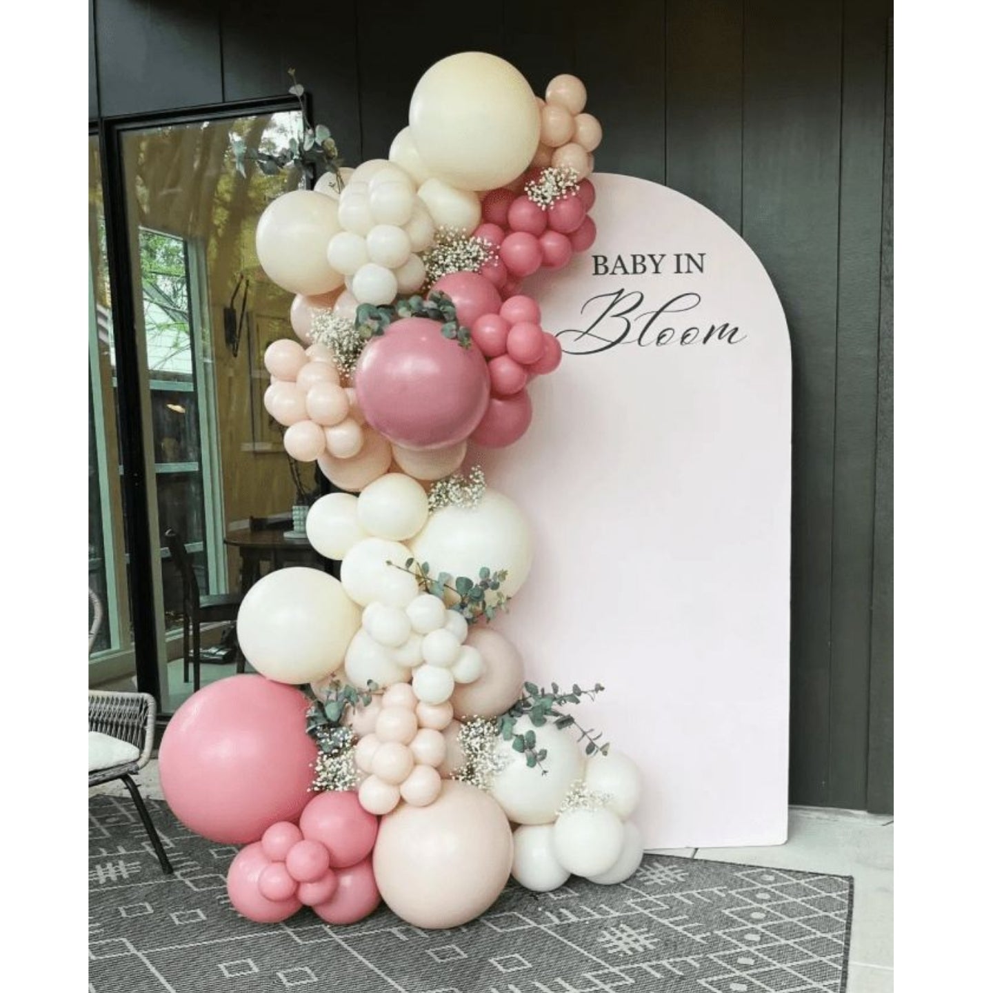 Balloon arch with pink and white balloons in front of a 'Baby in Bloom' sign.
