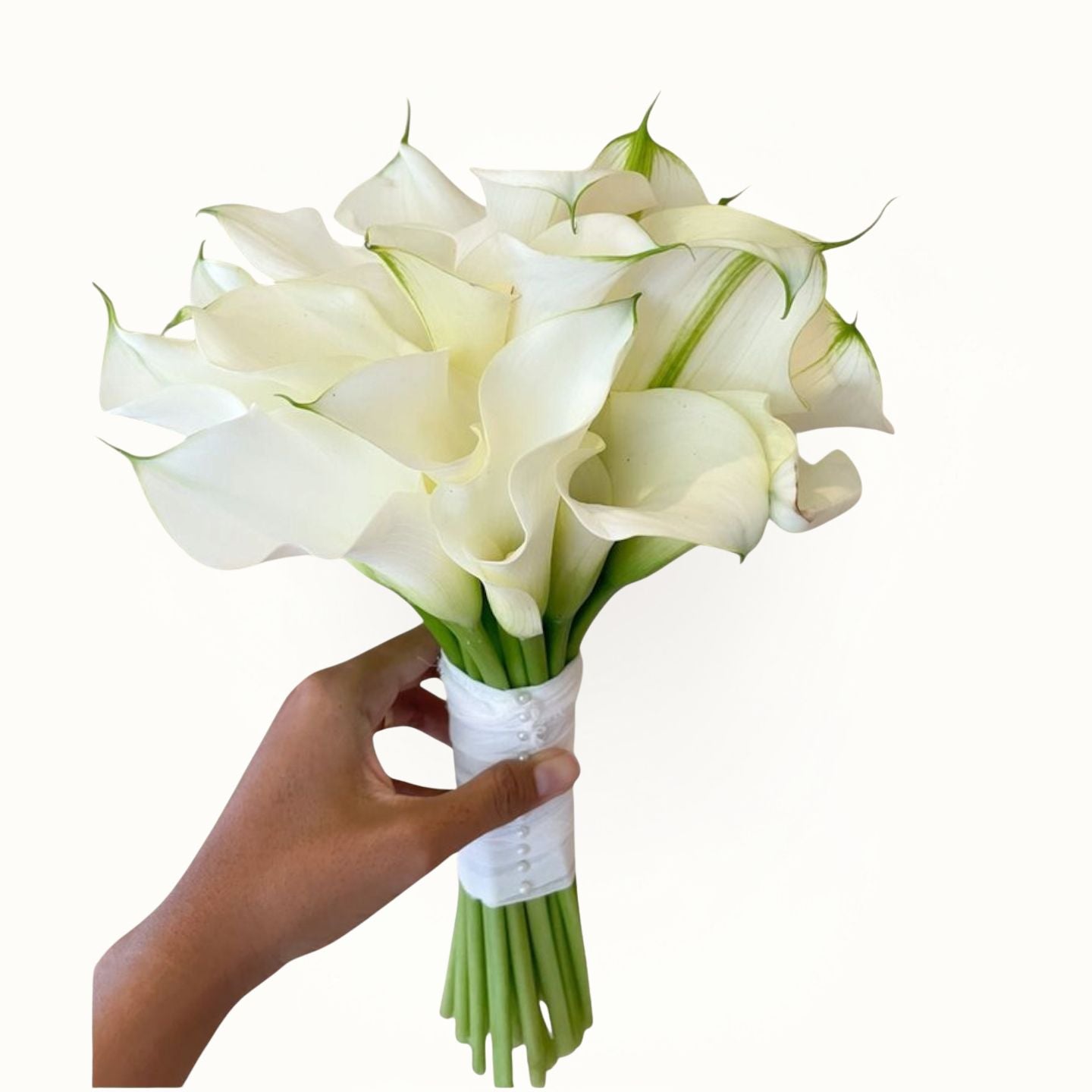 Bouquet of white calla lilies held by a hand on a white background