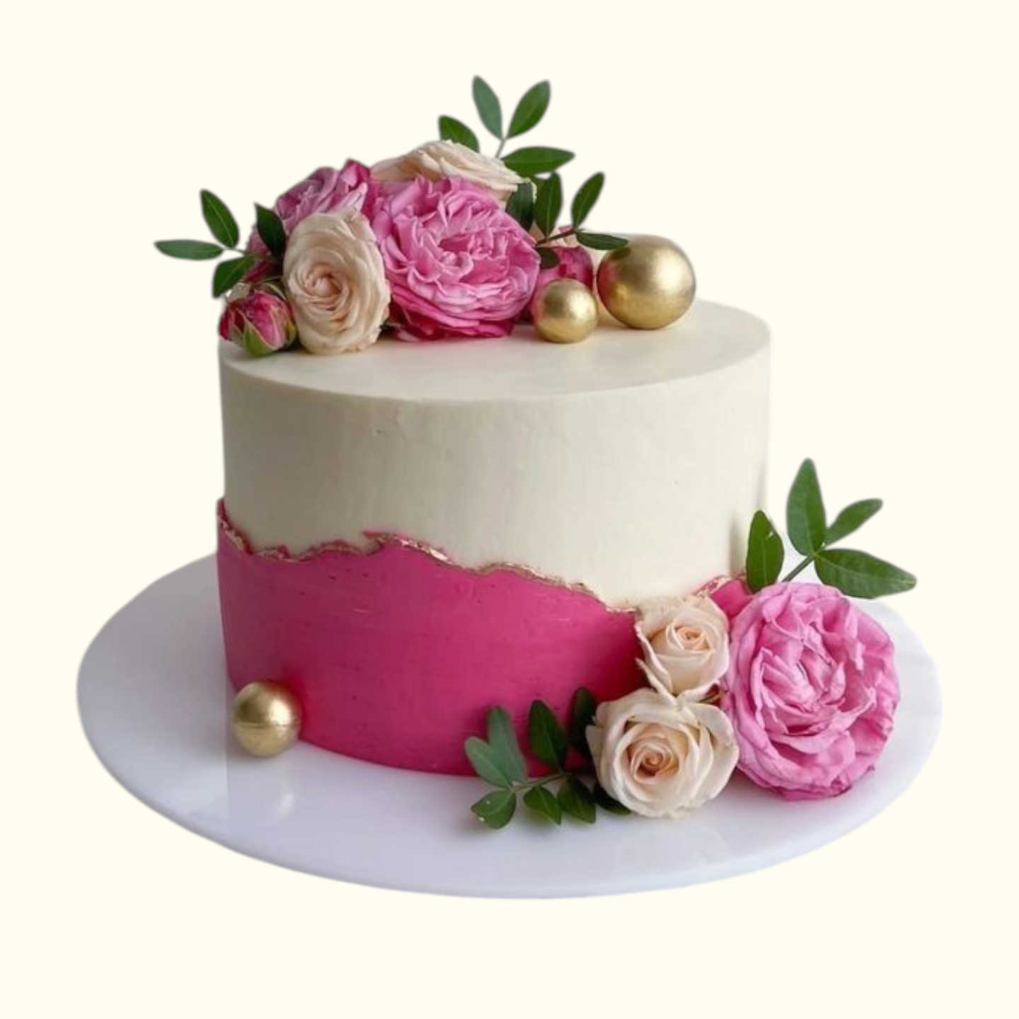 Decorative cake with pink and white frosting, flowers, and gold patels