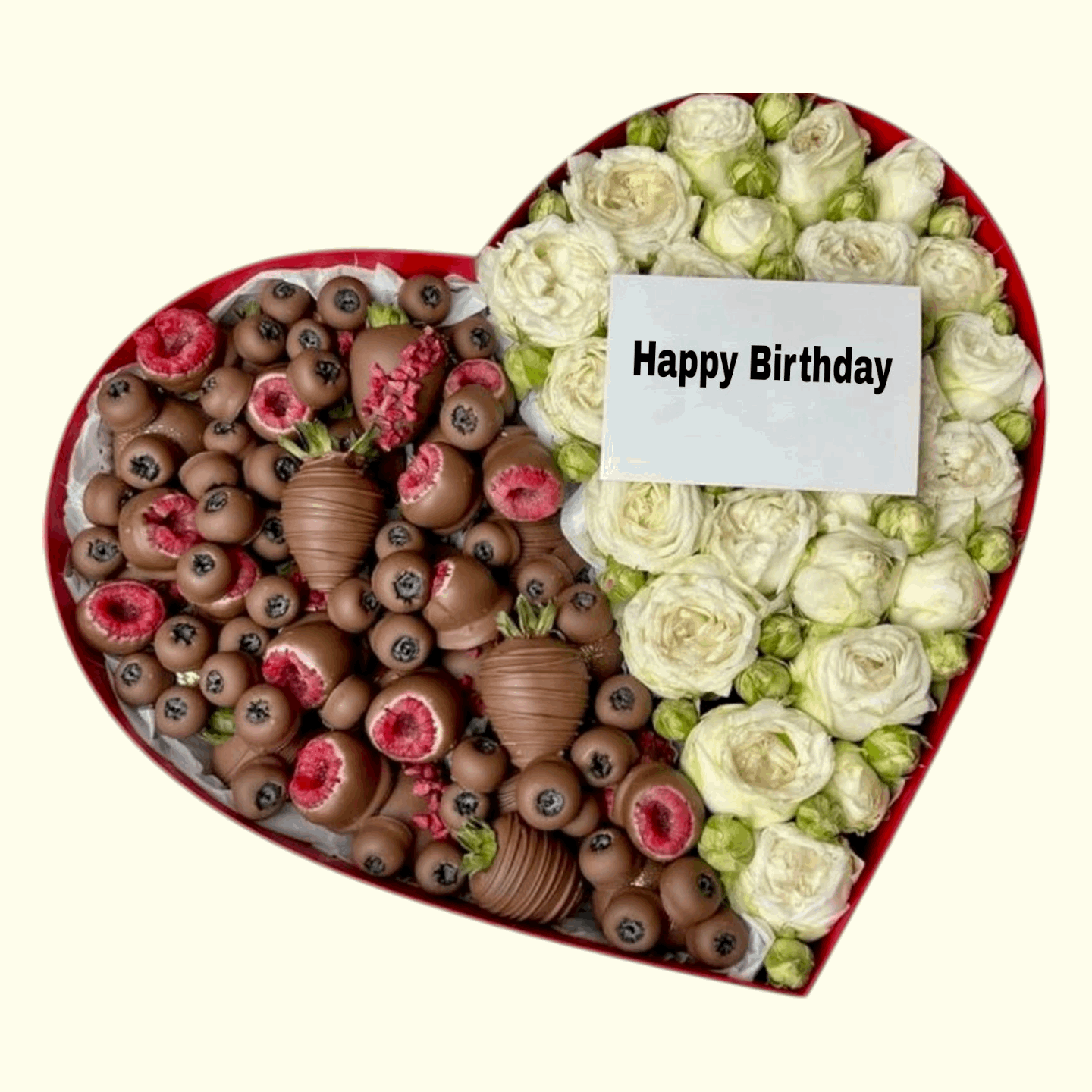 Heart-shaped arrangement of chocolates and flowers with a 'Happy Birthday' card on a white background