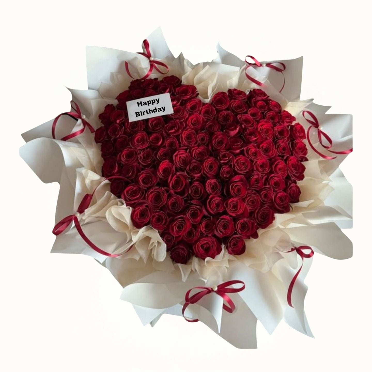 Heart-shaped bouquet of red roses with white paper and red ribbons on a white background