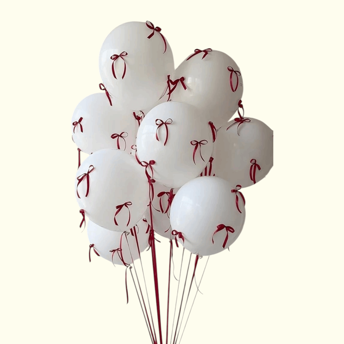 White balloons with red ribbons tied to strings on a white background