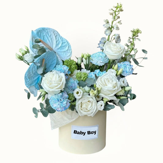 Floral arrangement in a box labeled 'Baby Boy' on a white background
