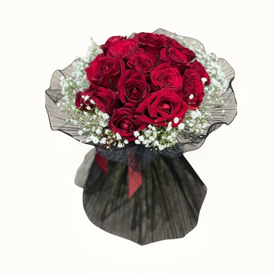 Bouquet of red roses with a black wrap on a white background