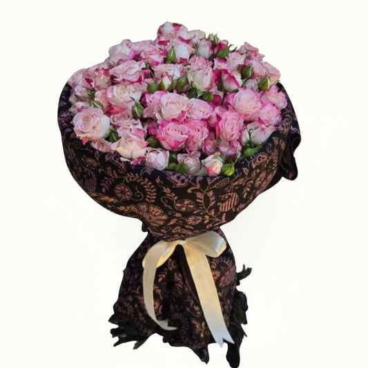 Pink Bouquet of pink and white flowers wrapped in black lace with a white ribbon