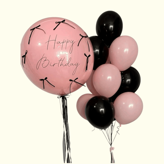 Pink and black balloons with 'Happy Birthday' text on a white background