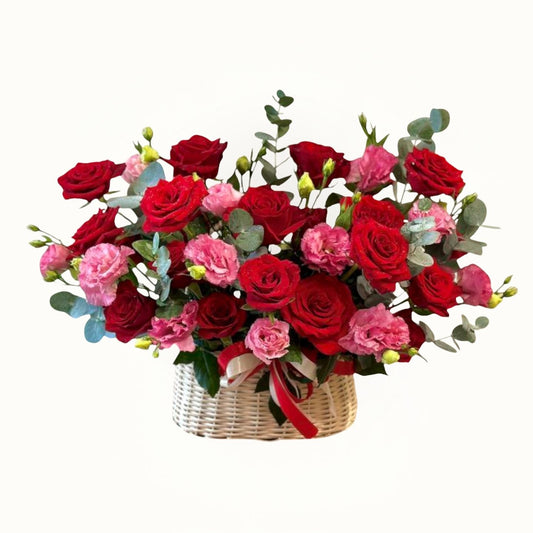 Bouquet of red and pink roses in a woven basket on a white background