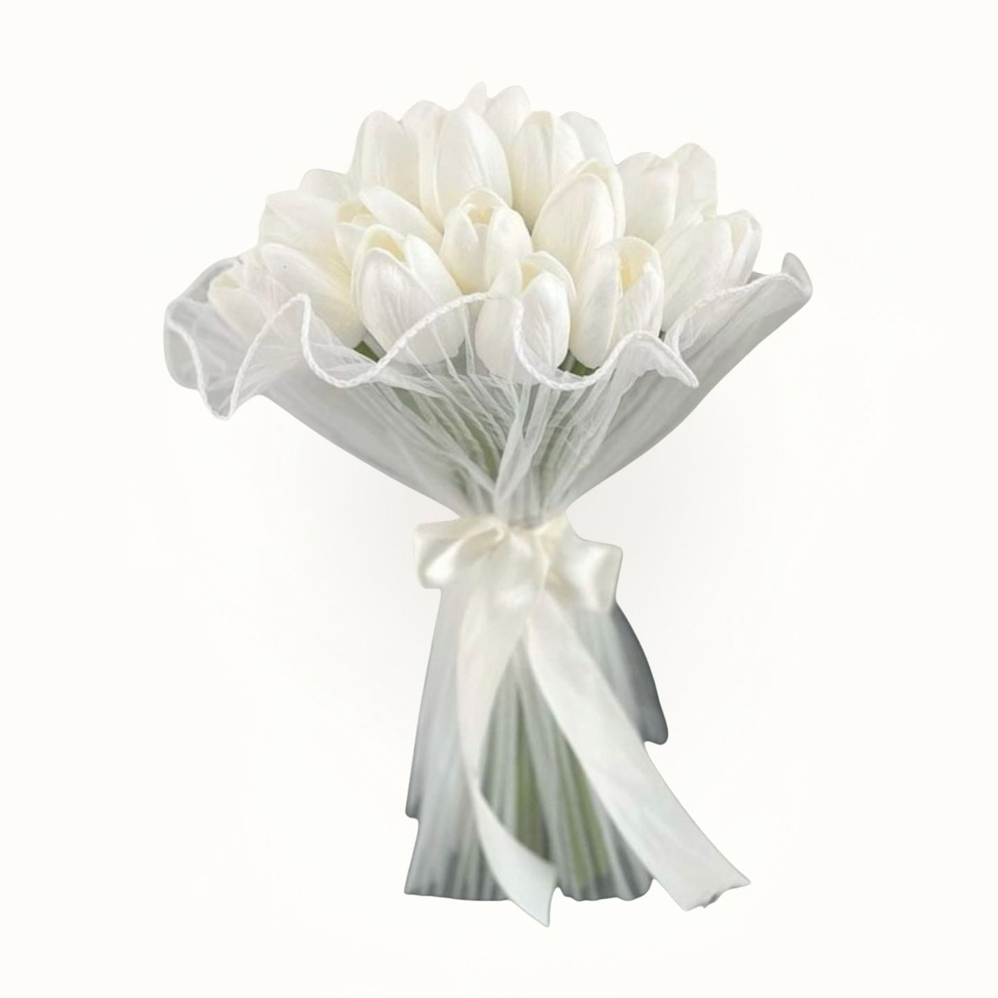 Bouquet of white flowers wrapped in sheer paper with a ribbon on a white background