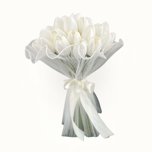 Bouquet of white flowers wrapped in sheer paper with a ribbon on a white background