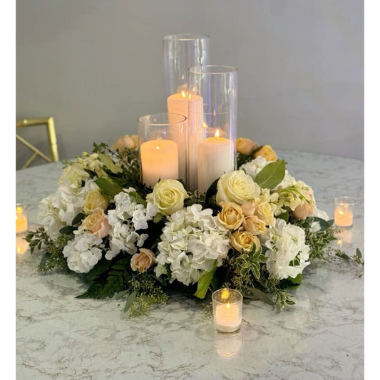 Floral arrangement with candles on a marble surface