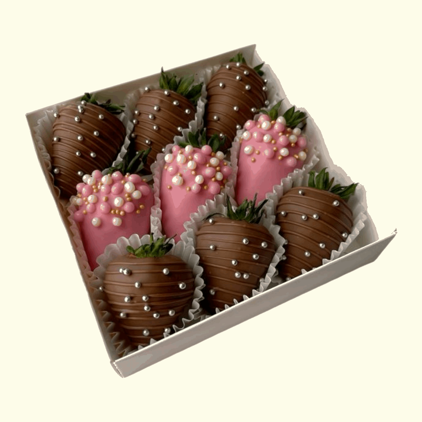 Box of chocolate-covered strawberries with pink and gold decorations on a white background