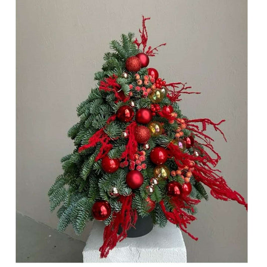 Decorative Christmas tree with red ornaments and ribbons on a plain background