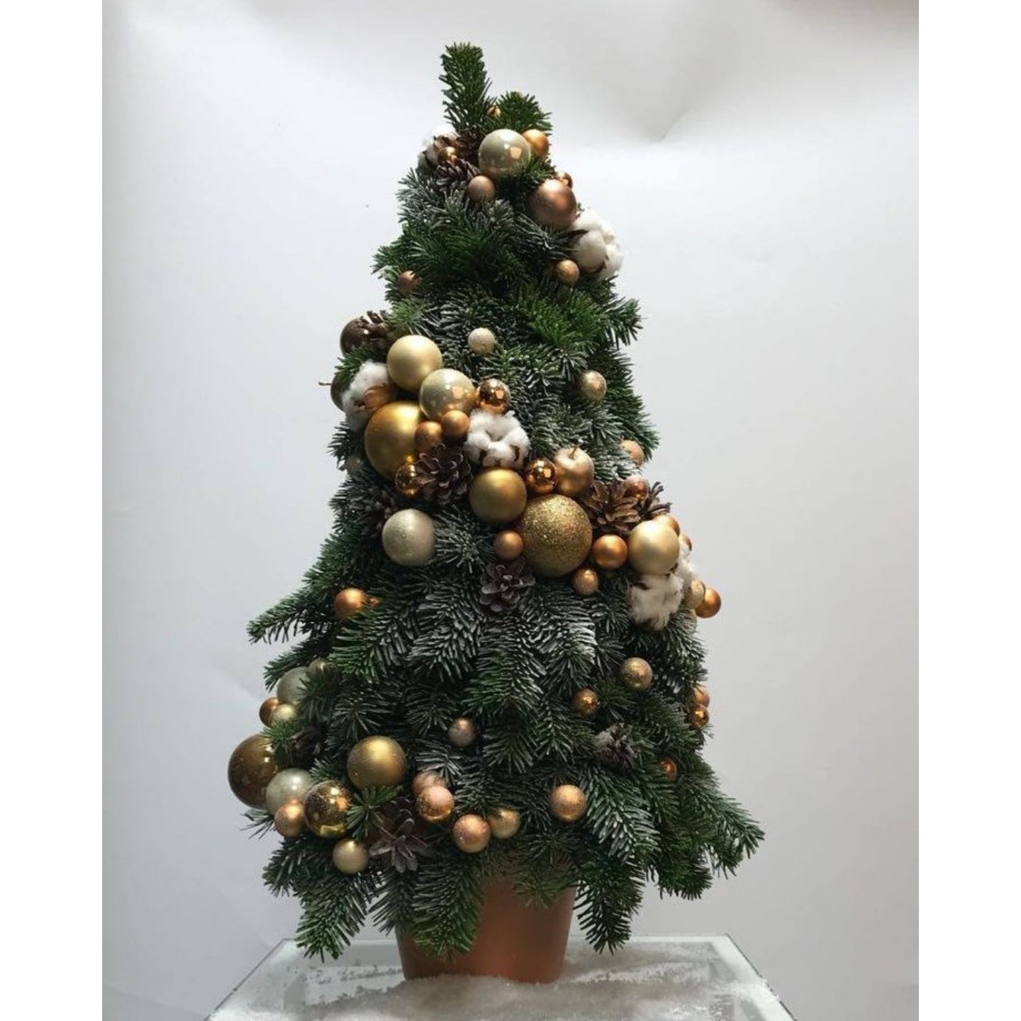 Decorative Christmas tree with gold and silver ornaments on a white background
