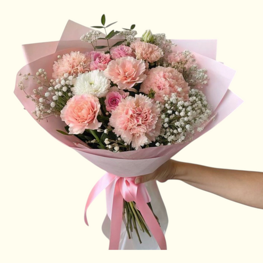 Bouquet of pink and white flowers with a pink ribbon held by a hand | Pink Flower Bouquet Dubai UAE