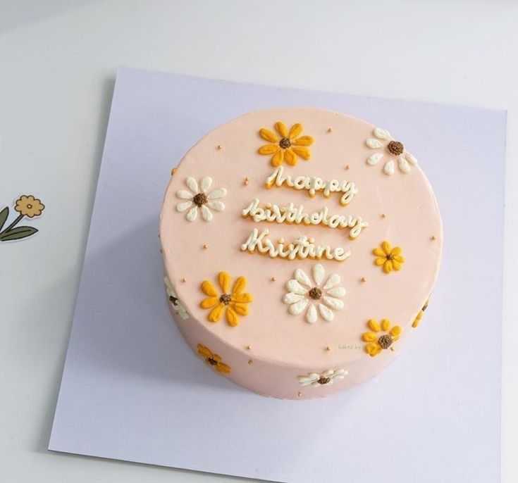 Round cake with floral decorations and 'Happy Birthday Kristine' text on a white background

