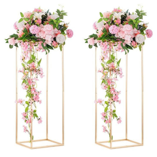 Two floral arrangements on gold stands against a white background