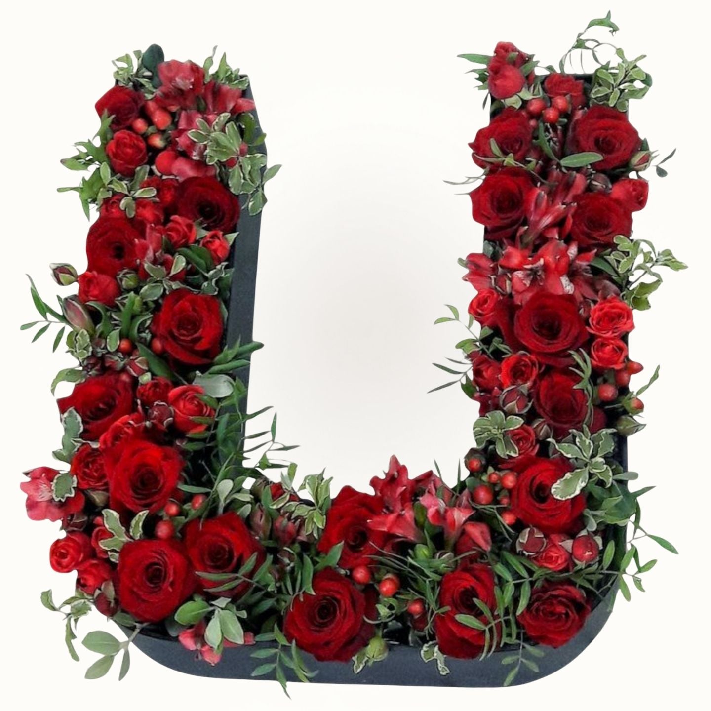 Floral arrangement shaped like the letter 'L' with red roses and greenery on a white background