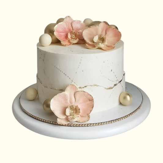Small white cake with floral decorations on a white background