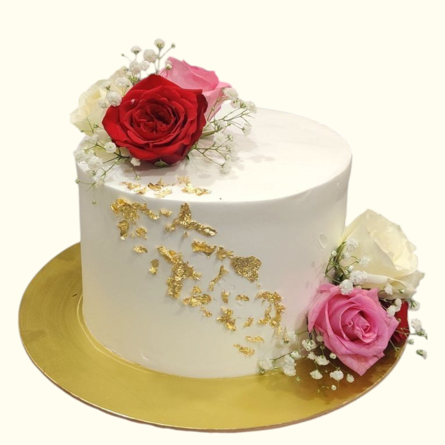 White cake with gold leaf decorations and pink roses 