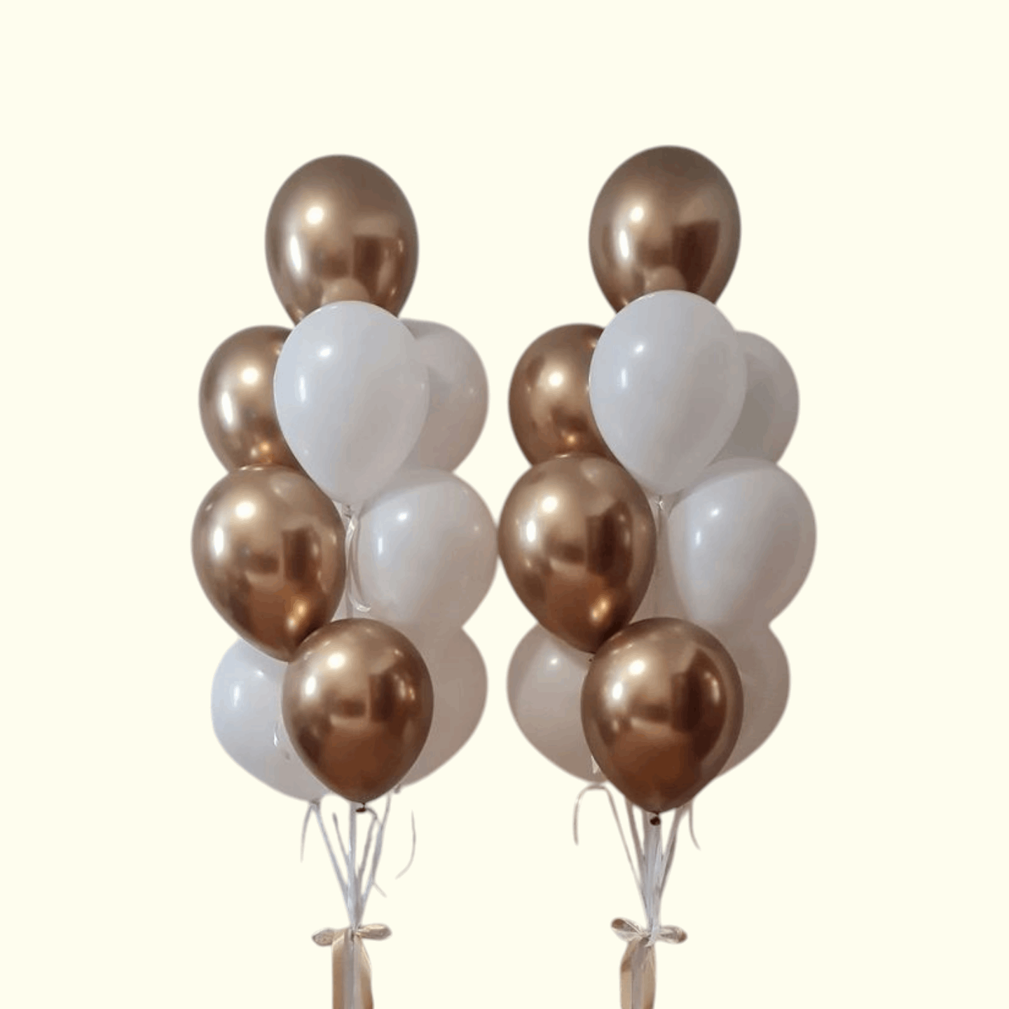 Two bunches of balloons with gold, white, and bronze colors on a white background