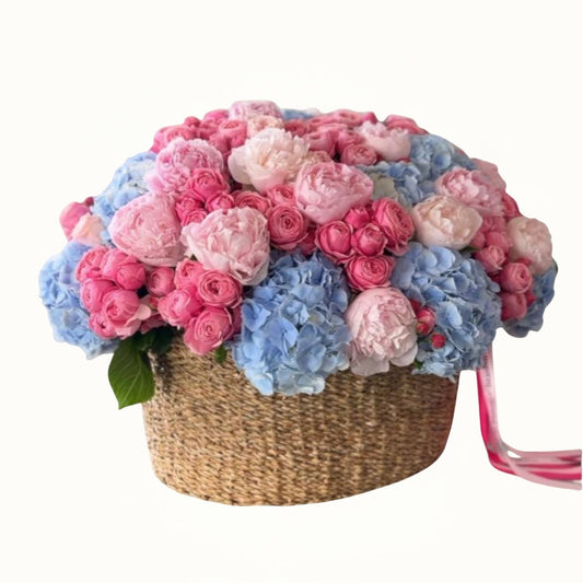 Basket filled with pink and blue flowers on a white background
