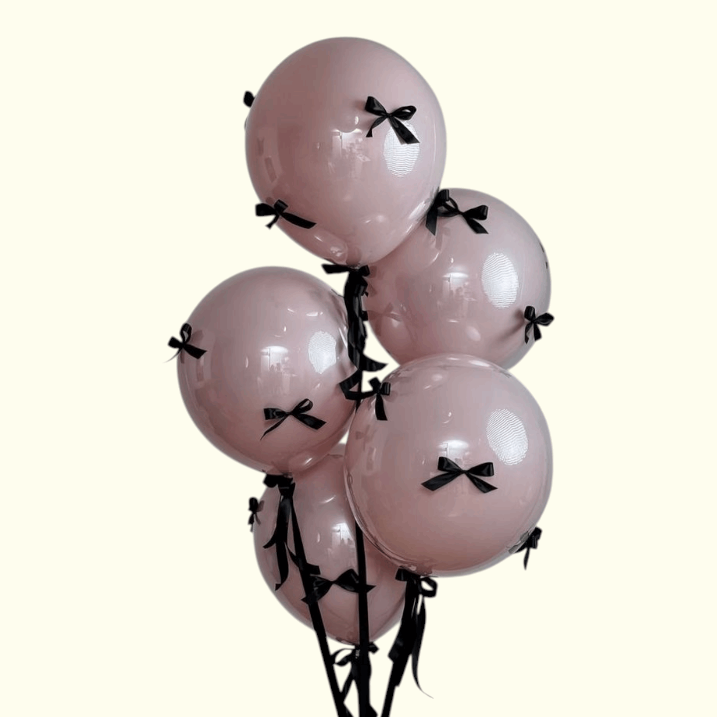 Pink balloons with black ribbons on a white background