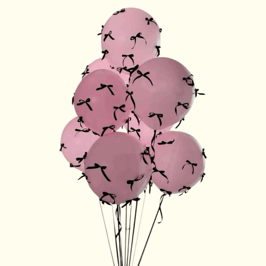 Pink balloons with black ribbons on a white background
