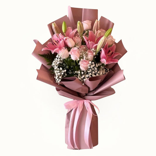 Bouquet of pink flowers wrapped in brown paper with a pink ribbon on a white background
