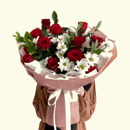 Red Roses, White Flower and White Leaf flower bouquet with pink wrapping. 