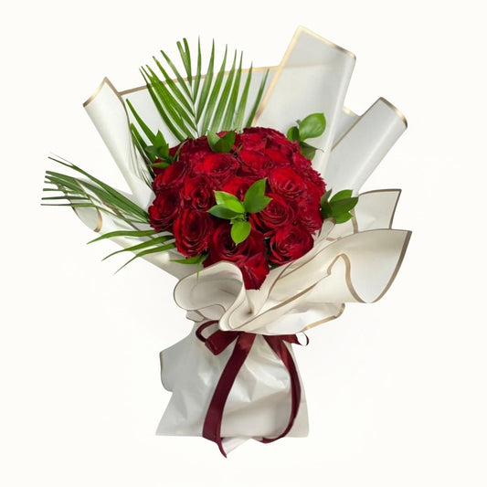 Bouquet of red roses with green leaves and white ribbon on a white background