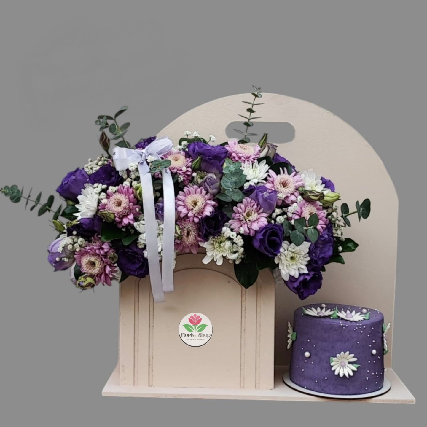 Floral arrangement with a purple cake on a gray background