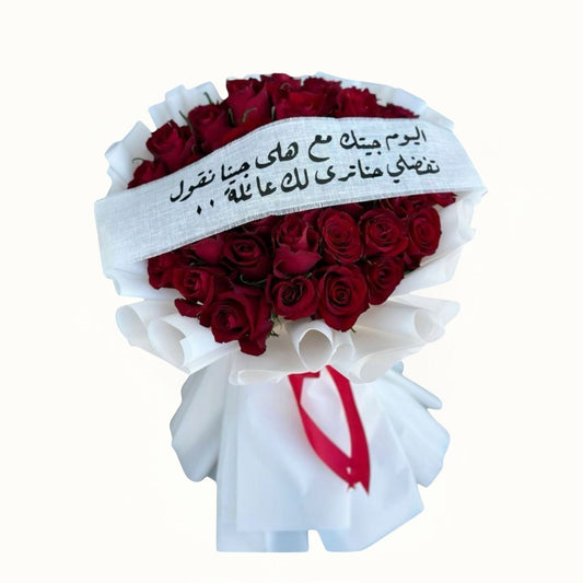 Bouquet of red roses with a white ribbon and Arabic text on a white background