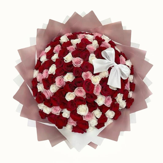 Bouquet of red, pink, and white roses with a white bow on a white background