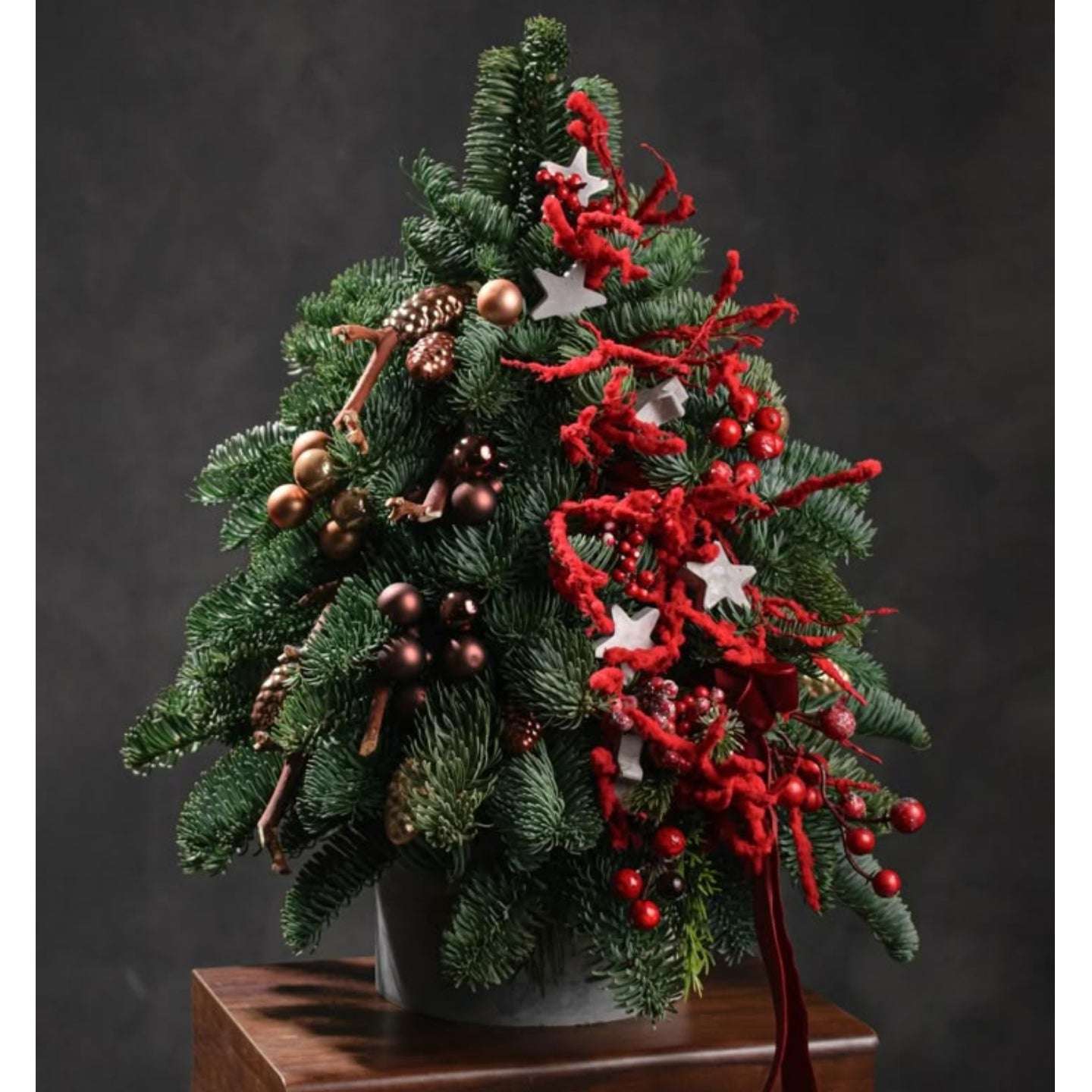 Decorative Christmas tree with red and gold ornaments on a dark background