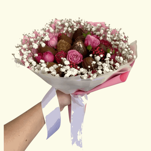 Bouquet of flowers and chocolates held by a person on a white background
