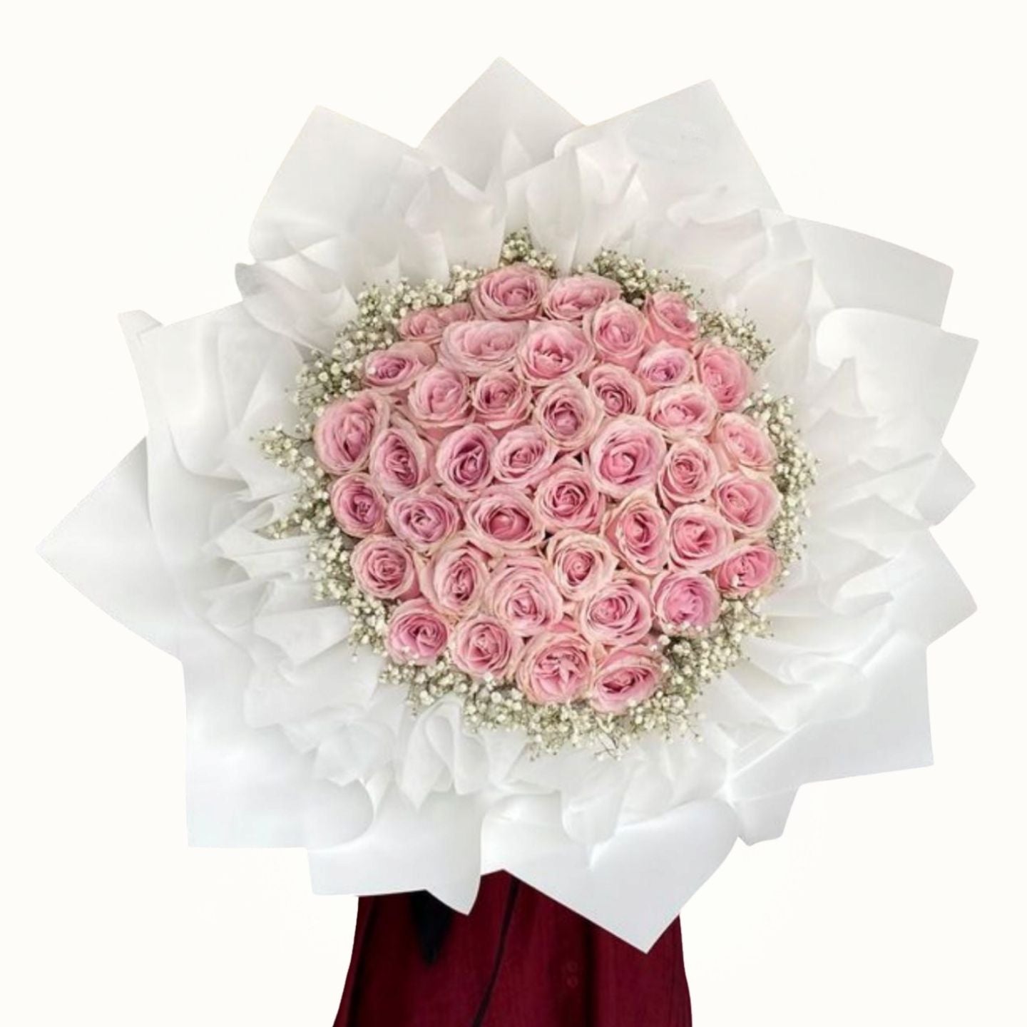 Bouquet of pink roses wrapped in white paper on a white background