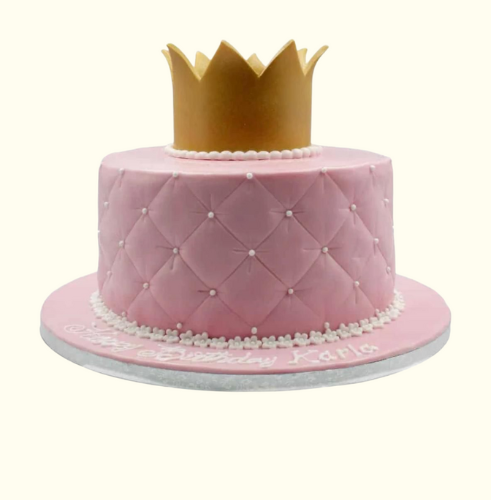 Pink cake with a gold crown on a white background