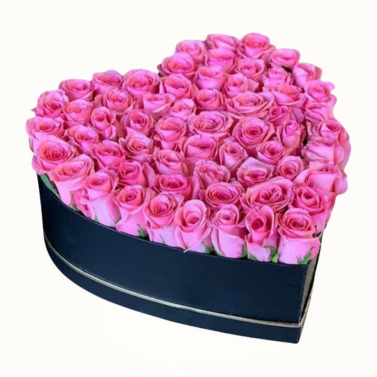 Heart-shaped box filled with pink roses on a white background