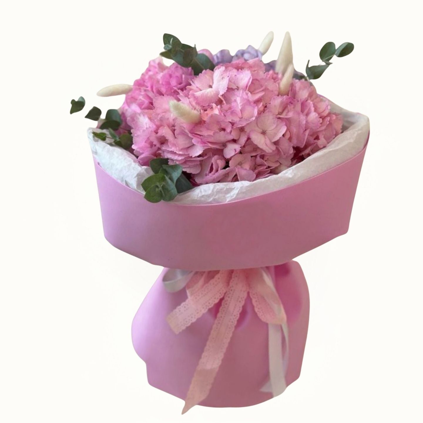 Pink bouquet of flowers in a pink container with a white background