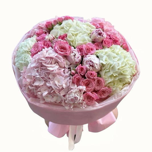 Flower Bouquet of pink and white flowers in a pink holder on a white background