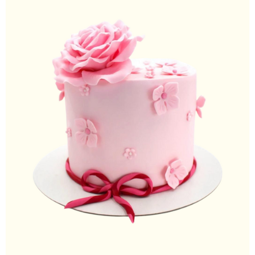 Pink cake with a large rose and decorative flowers on a white background