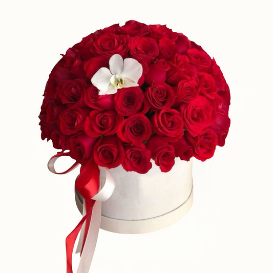 Bouquet of red roses with a white orchid in a white box on a white background