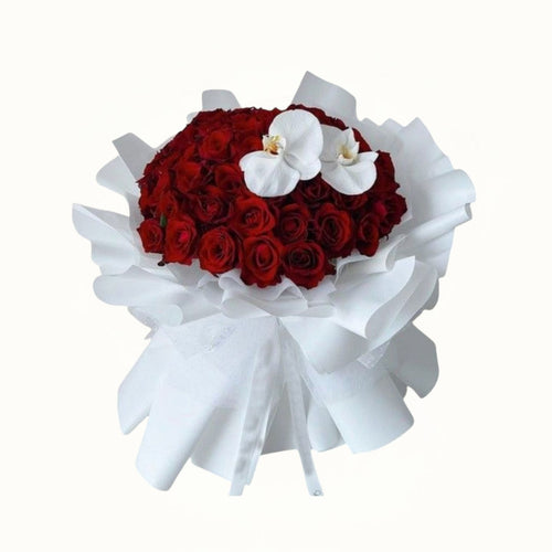 Bouquet of red roses with white orchids wrapped in white paper on a white background