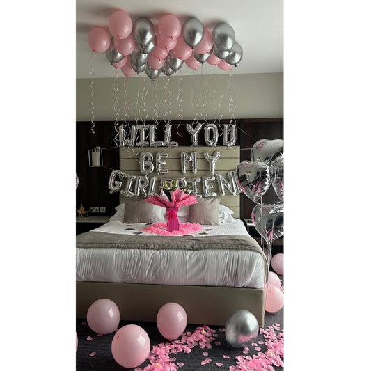 Decorated room with pink and silver balloons and 'TILL YOU BE MY GIRLFRIEND' sign.