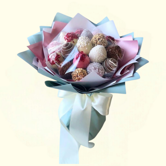 Bouquet of assorted pastries wrapped in paper with a white ribbon on a light background