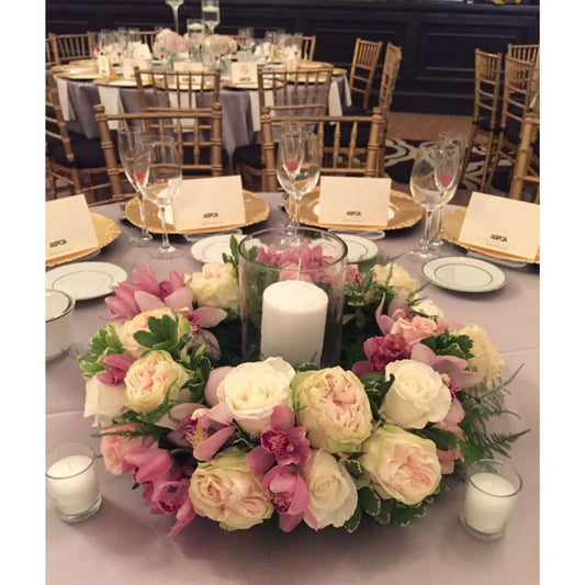 Decorated table with floral centerpiece, candles, and name cards in a formal setting.
