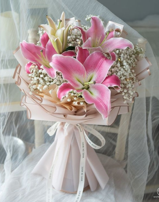 White roses and gypsophila bouquet with light pink wrapping 