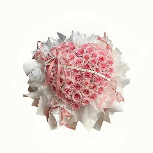 Heart-shaped bouquet of pink roses with white ribbons 